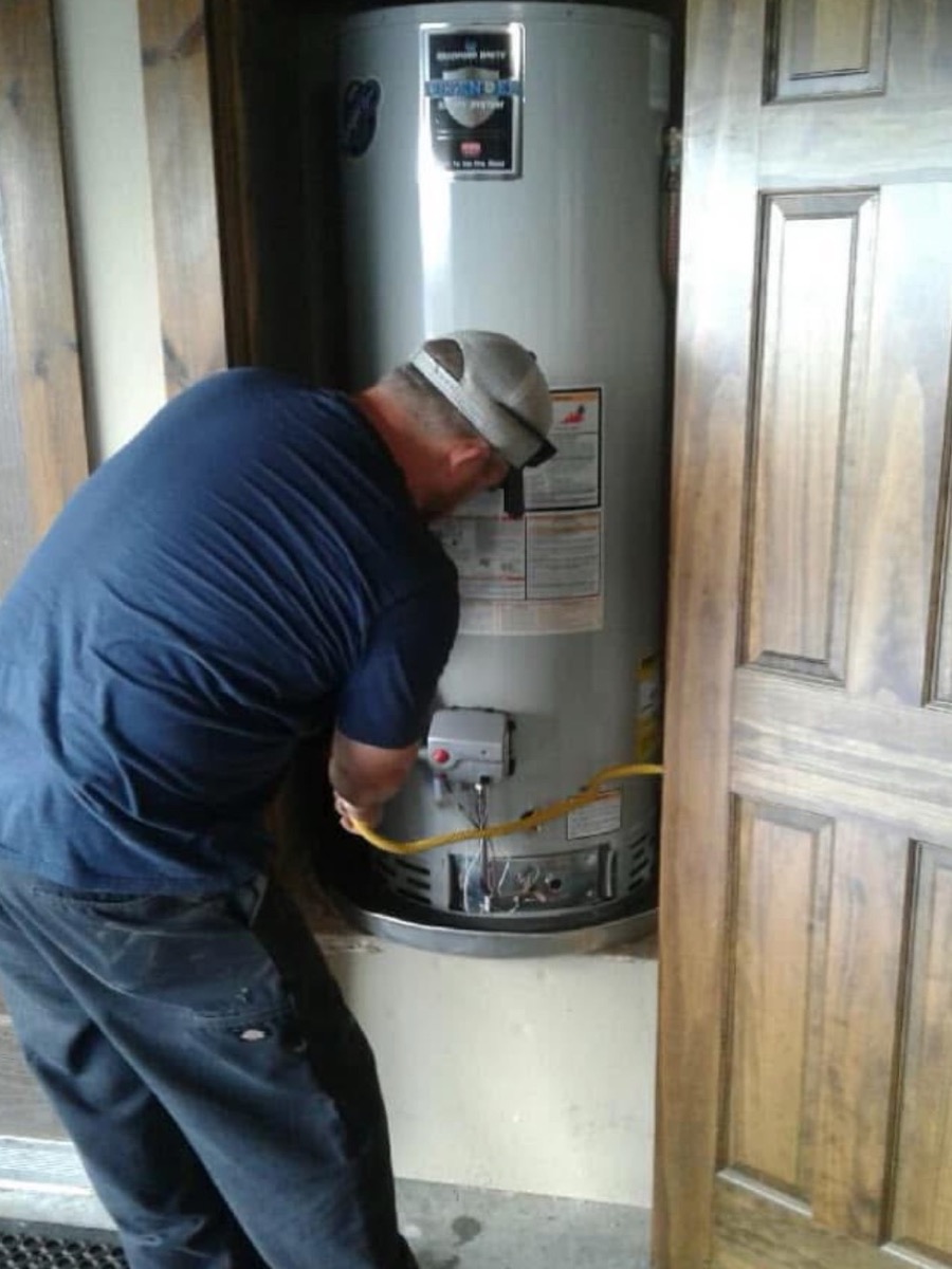 Hunter's Plumbing working on a residential water heater